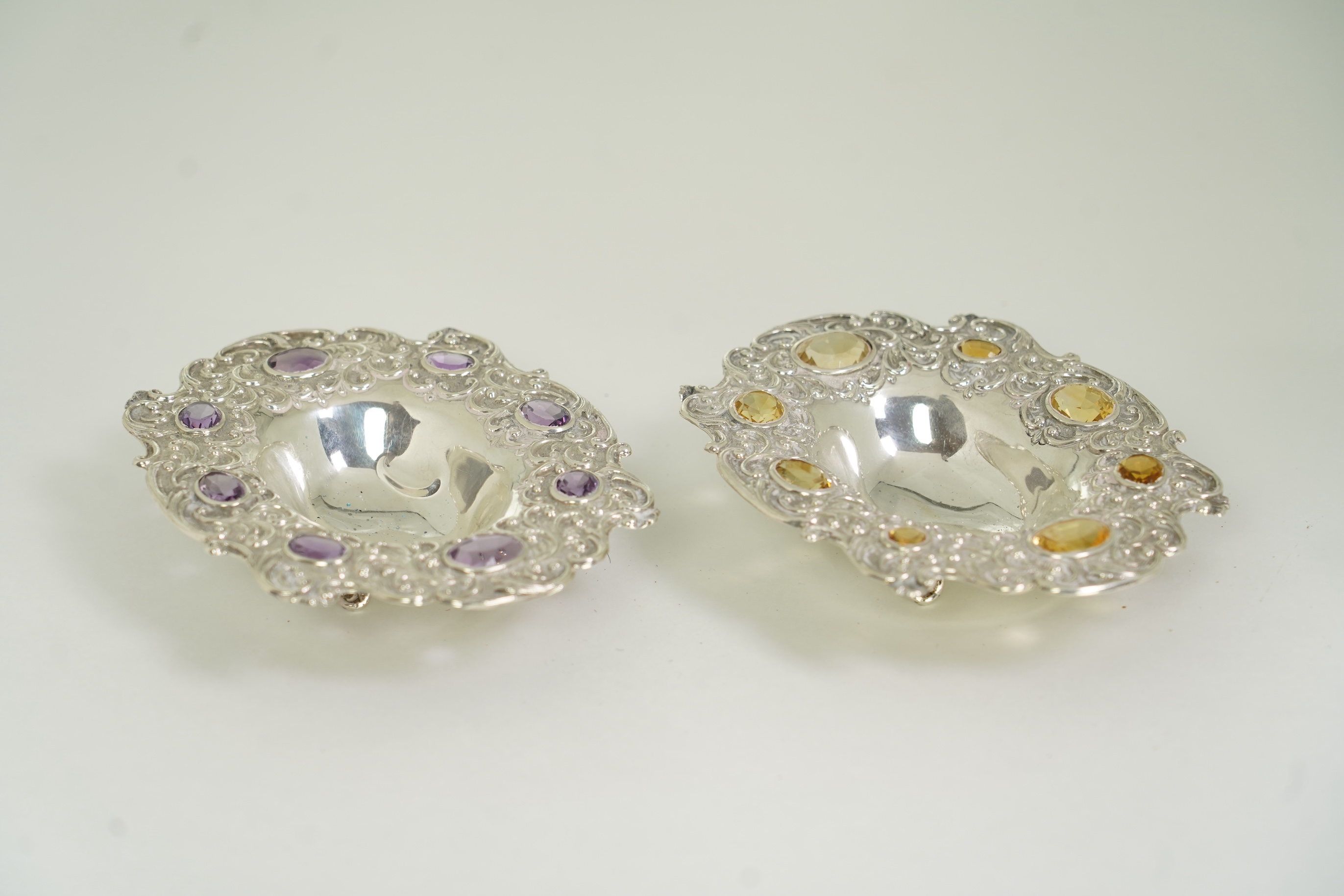 Two unusual late Victorian repousse silver dishes, by Daniel & John Welby, one border inset with eight oval cut amethysts, the other with eight oval cut citrines